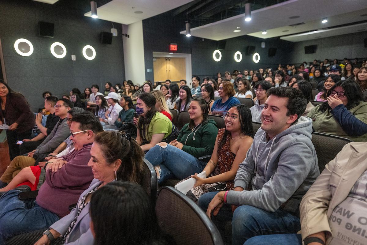 Photo of smiling students in well-lit auditorium