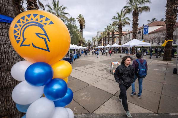 Photo of students walking along the Paseo during a tabling event